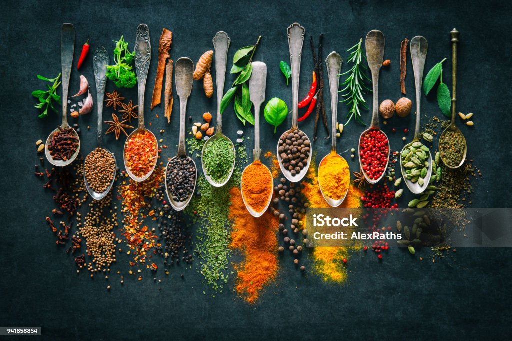 Colourful various herbs and spices for cooking on dark background